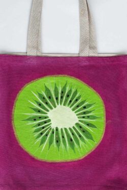 Green kiwi on pink background tote bag