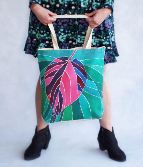 pink purple leaf on green background tote bag in hands