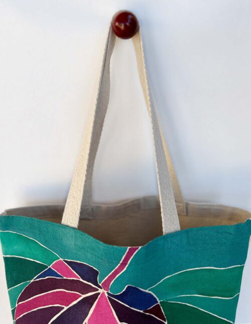 pink purple leaf on green background tote bag top view