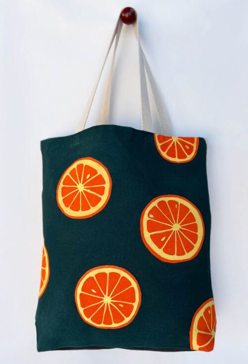 oranges on dark green background tote bag hanging front view