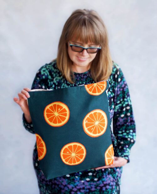 oranges on dark green background tote bag in woman's hands