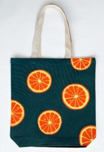 oranges on dark green background tote bag